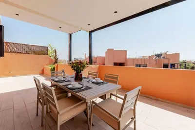 a dining table and chairs on a balcony at Penthouse with Rooftop and Jardin Majorelle View in Marrakech