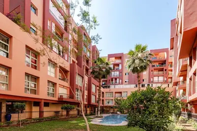 an apartment building with a pool in front of it at Penthouse with Rooftop and Jardin Majorelle View in Marrakech