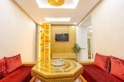 a living room with two red couches and a tv at HAGS Apartment - Traditional Modern Apartment, full AC, 10m from airport in Marrakech