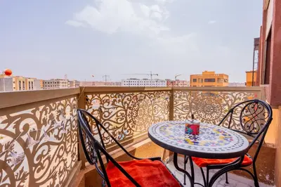 a table and chairs on a balcony with a view at HAGS Apartment - Traditional Modern Apartment, full AC, 10m from airport in Marrakech