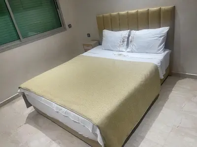 a bedroom with a large bed with white sheets and pillows at LA PERLE ANDALOUSE Quartier HIVERNAGE in Marrakech
