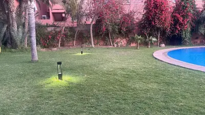 a yard with a pool and trees and a resort at LA PERLE ANDALOUSE Quartier HIVERNAGE in Marrakech