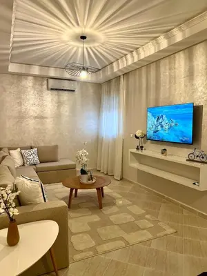 a living room with a couch and a tv at La perle d'atlas appartement in Marrakech