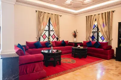 a living room with red couches and two tables at Villa Marrakchia - Palais d'hôtes in Marrakech