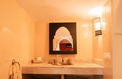 a bathroom with a sink and a mirror at Villa Marrakchia - Palais d'hôtes in Marrakech