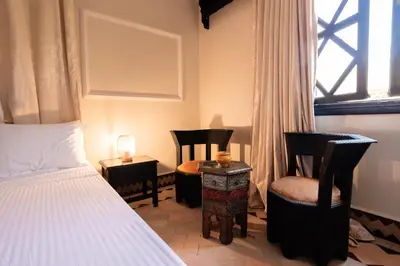 a bedroom with two chairs and a bed and a window at Villa Marrakchia - Palais d'hôtes in Marrakech