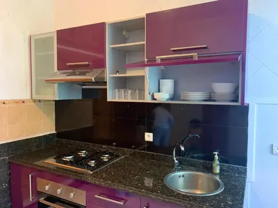 a kitchen with purple cabinets and a sink at Appartement Gueliz in Marrakech