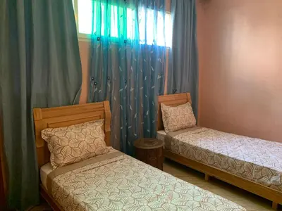 a bedroom with two beds and a window with curtains at Appartement Gueliz in Marrakech