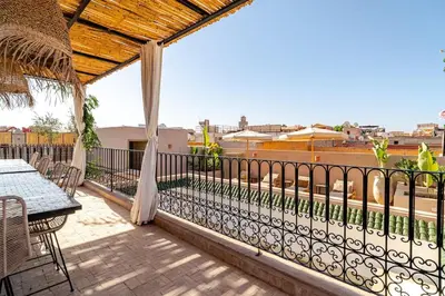 a balcony with a table and chairs and a view of a city at Riad Dar Tonka in Marrakech