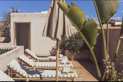 a group of chairs and an umbrella on a patio at Riad Dar Tonka in Marrakech