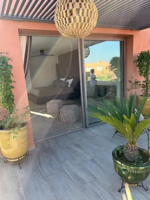 a patio with plants and a large glass door at Imagine Villa in Marrakech
