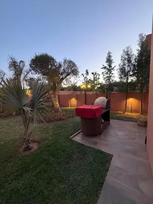 a patio with a red bench in a yard at Imagine Villa in Marrakech