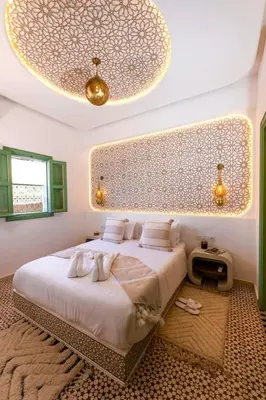 a bedroom with a large bed with a large ceiling at Riad DAR ELMA NOI in Marrakech