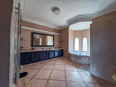 a large bathroom with a tub and a mirror at Villa des SONGES in Marrakech