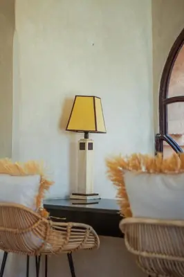 a lamp on a table next to two chairs at Villa des SONGES in Marrakech