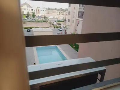 a view of a swimming pool from a window of a building at Logement Confort Résidence Fermée avec Piscine in Marrakech