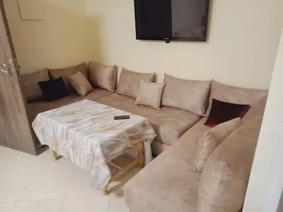 a living room with a couch and a table at Logement Confort Résidence Fermée avec Piscine in Marrakech