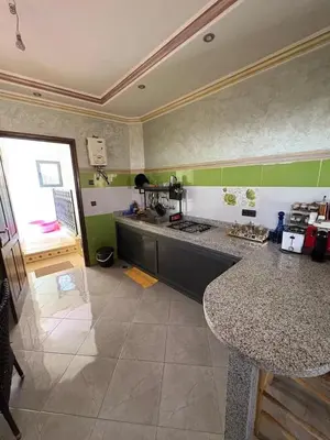 a kitchen with granite counter tops and green walls at Airport appartement , penthouse in Marrakech