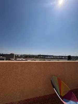a colorful umbrella sitting next to a wall with an airport at Airport appartement , penthouse in Marrakech