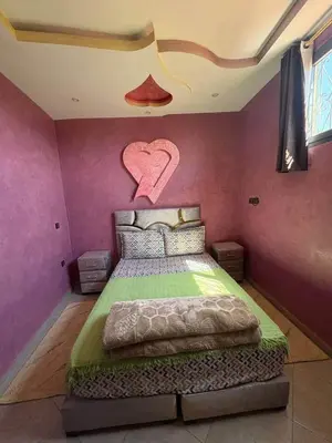 a bedroom with a bed with a heart on the wall at Airport appartement , penthouse in Marrakech