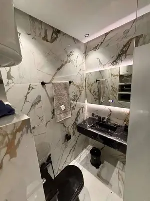 a marble bathroom with a sink and a toilet at Appartement moderne in Marrakech