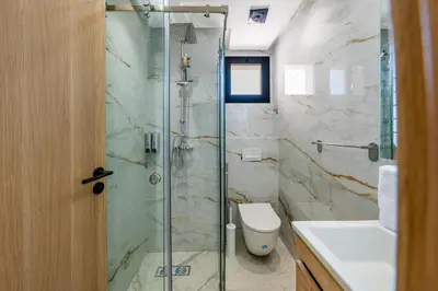 a bathroom with a shower and a toilet and a sink at Modern Studio in Hivernage with Pool Access in Marrakech