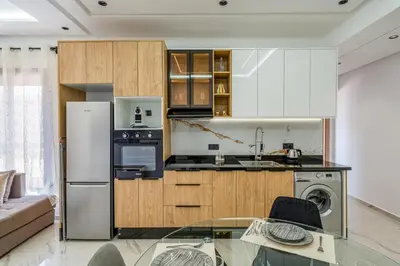 a kitchen with white cabinets and a glass table at Modern Studio in Hivernage with Pool Access in Marrakech