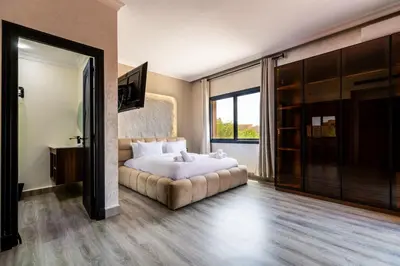 a bedroom with a bed and a large window at 4 Bed Villa lagune River Palm Marrakech with Pool in Marrakech