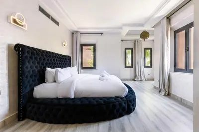 a bedroom with a large bed with a black headboard at 4 Bed Villa lagune River Palm Marrakech with Pool in Marrakech