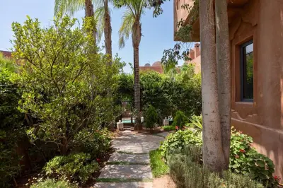 a stone walkway next to a building with palm trees at 4 Bed Villa lagune River Palm Marrakech with Pool in Marrakech