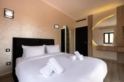 a bedroom with a large white bed with towels on it at 4 Bed Villa lagune River Palm Marrakech with Pool in Marrakech