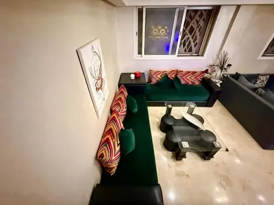 a living room with a green couch and a table at Maison H&A in Marrakech