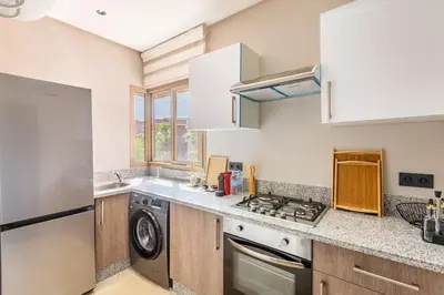 a kitchen with a stove top oven next to a dishwasher at Spacious luxury 3BR by the pool in Marrakech