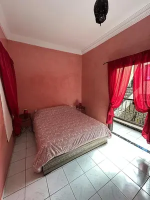 a bedroom with a bed with red walls and windows at Riad Marrakech in Marrakech