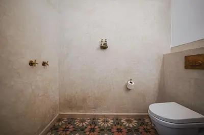 a bathroom with a toilet and a tile floor at Nahla Wellness in Marrakech