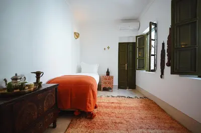 a bedroom with a bed and a dresser and a mirror at Nahla Wellness in Marrakech
