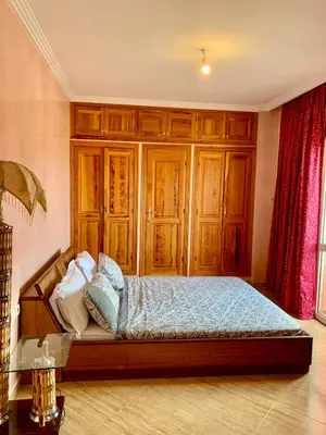 a bedroom with a bed with wooden cabinets at Appartement Marrakechi in Marrakech