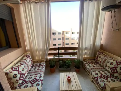 a balcony with couches and a table and a window at Berber Atlas Marrakech with Pool in Marrakech