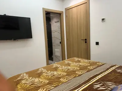 a bedroom with a bed and a flat screen tv at Aube Hivernage appartement in Marrakech