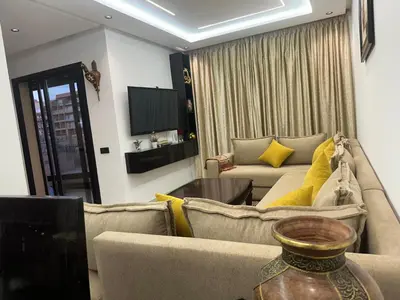 a living room with a couch and a table at Aube Hivernage appartement in Marrakech