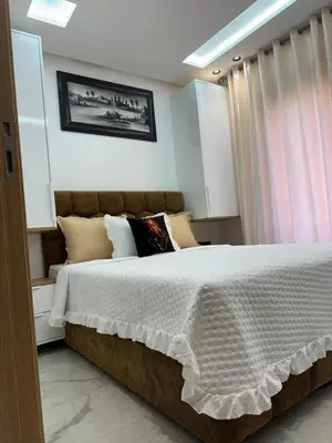 a bedroom with a large bed with white sheets and pillows at Aube Hivernage appartement in Marrakech
