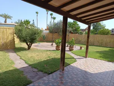 a patio with two potted plants in a yard at Villa Yasmine Marrakech in Marrakech