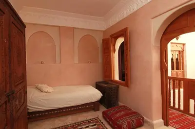 a small bedroom with a bed and a balcony at Riad Khalid Zrika Marrakech in Marrakech