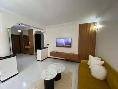 a living room with a couch and a tv on the wall at Condominium in Marrakech