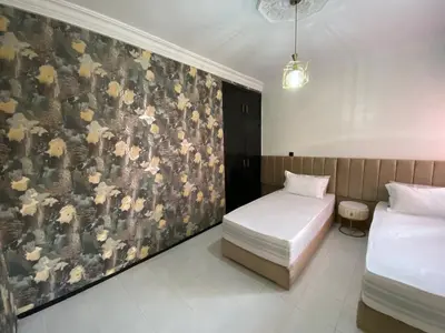 two beds in a room with a wall mural at Condominium in Marrakech