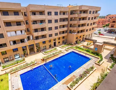 an overhead view of a swimming pool in front of a building at Appartement Haut de Gamme avec Piscine Privée et Grande Terrasse in Marrakech