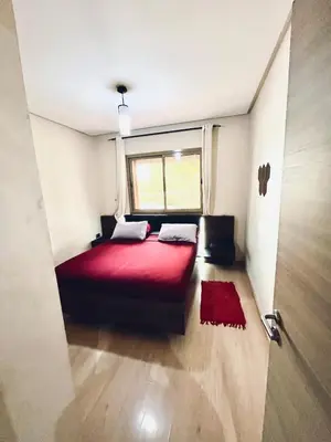 a bedroom with a red bed and a window at Cozy RC golf view pool & Atlas fiber optic 2 bedrooms in Marrakech