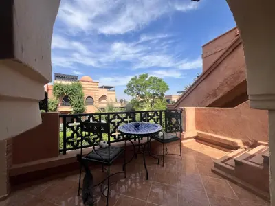 a patio with a table and chairs on a balcony at L'oasis d'Atlas Golf Resort in Marrakech