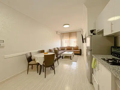 a kitchen and living room with a table and chairs at Studio Confort au Cœur de Guéliz proche Carré Eden in Marrakech