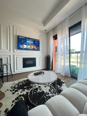 a living room with a white couch and a tv at Chanel home in Marrakech